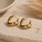Goudkleurige stainless steel oorringen met hoekige vorm, close-up