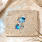 Blauwe semi-transparante oorbellen Charlotte Earrings van hi SISU op travertin steen
