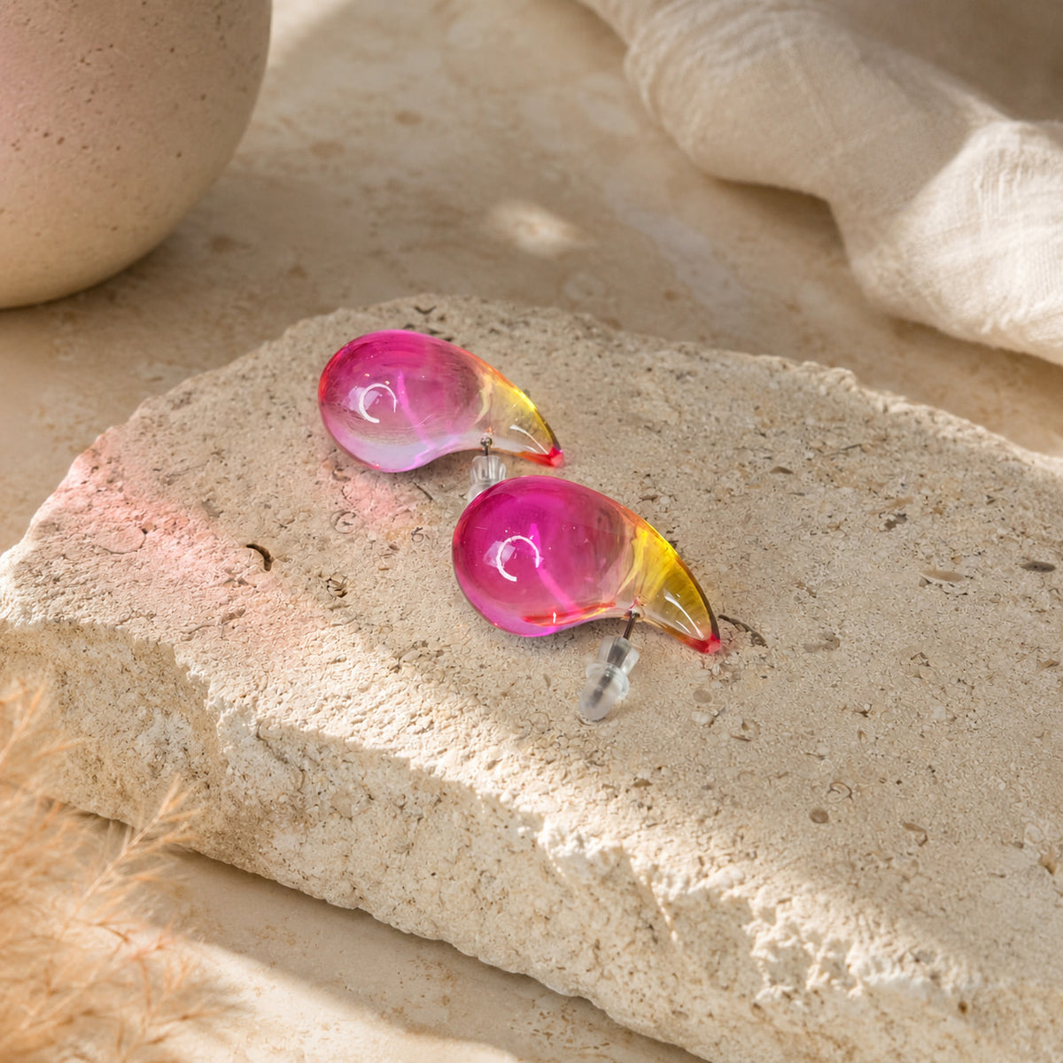 Roze semi-transparante druppel oorbellen Charlotte Earrings van hi SISU op steen met linnen 