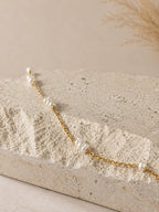 Gouden ketting met kleine zoetwaterparels, hangend gefotografeerd