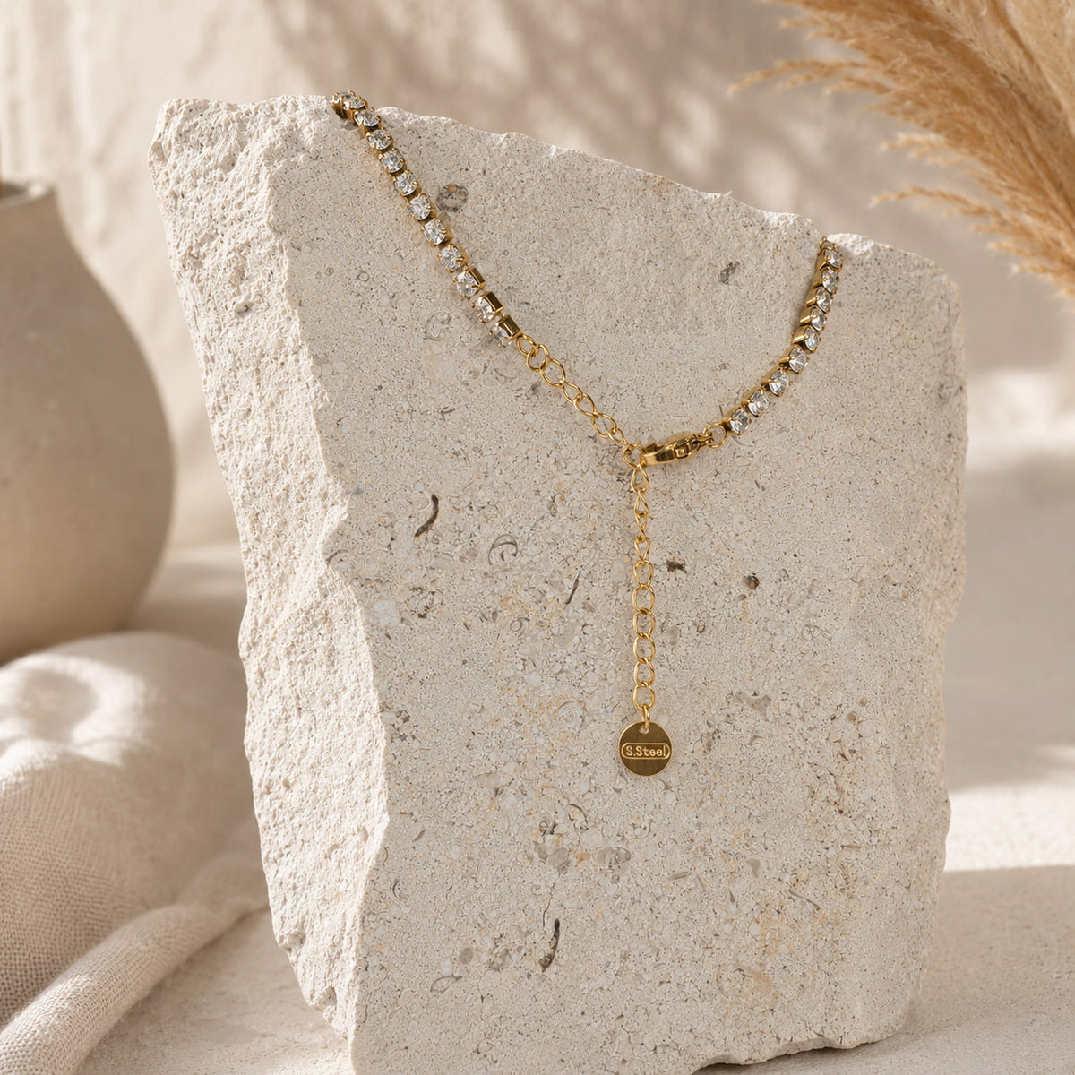Sluiting en verstelbaar verlengkettinkje van de goudkleurige tennis ketting Hailey Necklace van hi SISU, met stainless steel label